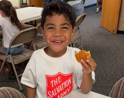Child eating at The Salvation Army with a smile.