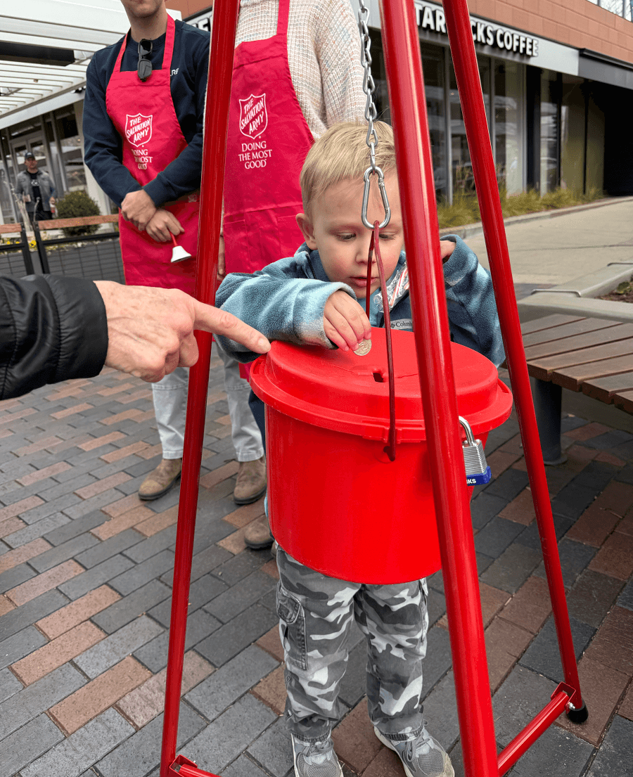 Little Boy Donating to Salvation Army Red Kettle